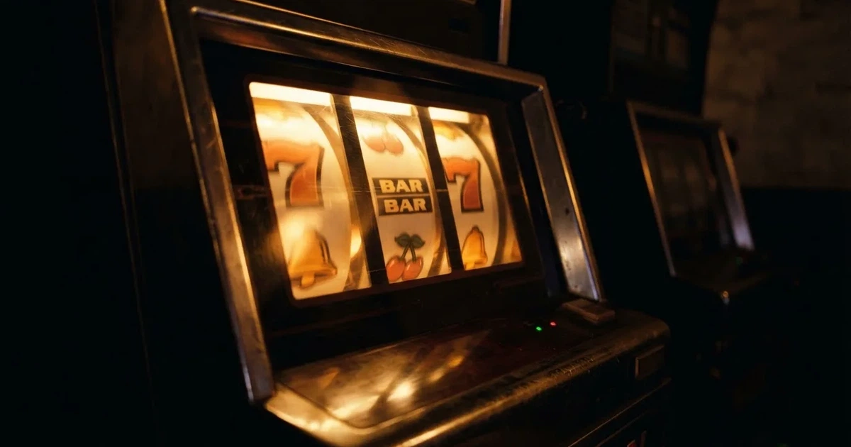 Rolos luminosos de uma slot machine numa sala escura, em grande plano — 10 euro casino em portugal